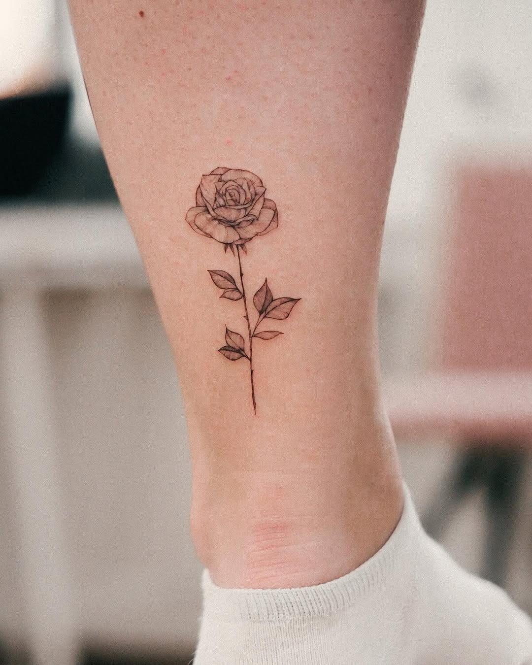 Elegant black line rose tattoo on leg Tattoo Design