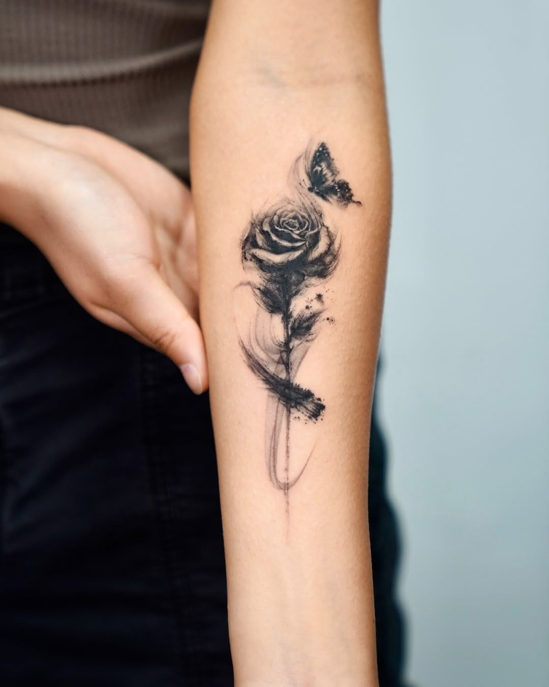 Elegant black rose tattoo with butterfly accent Tattoo Design