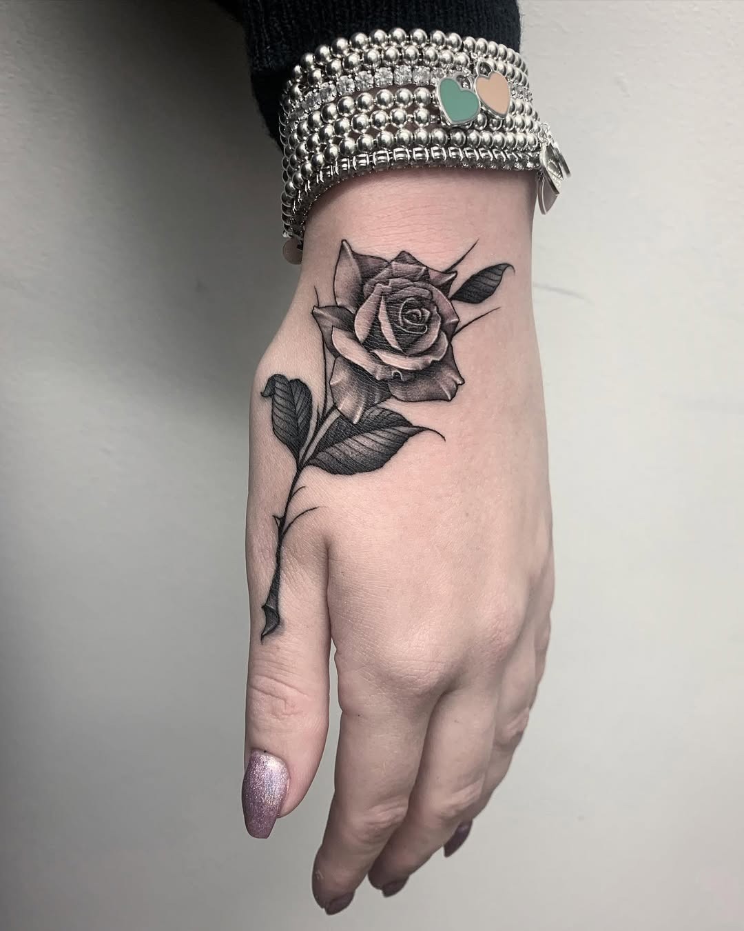 Stunning Black Ink Rose Tattoo on Hand Tattoo Design