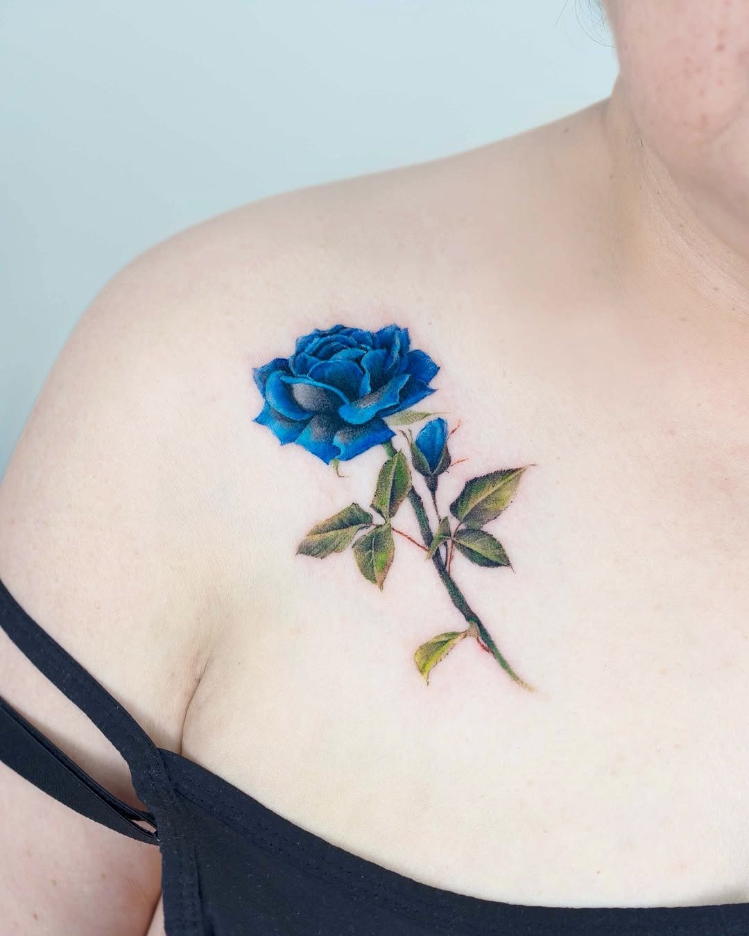 Vibrant blue rose tattoo on shoulder skin Tattoo Design