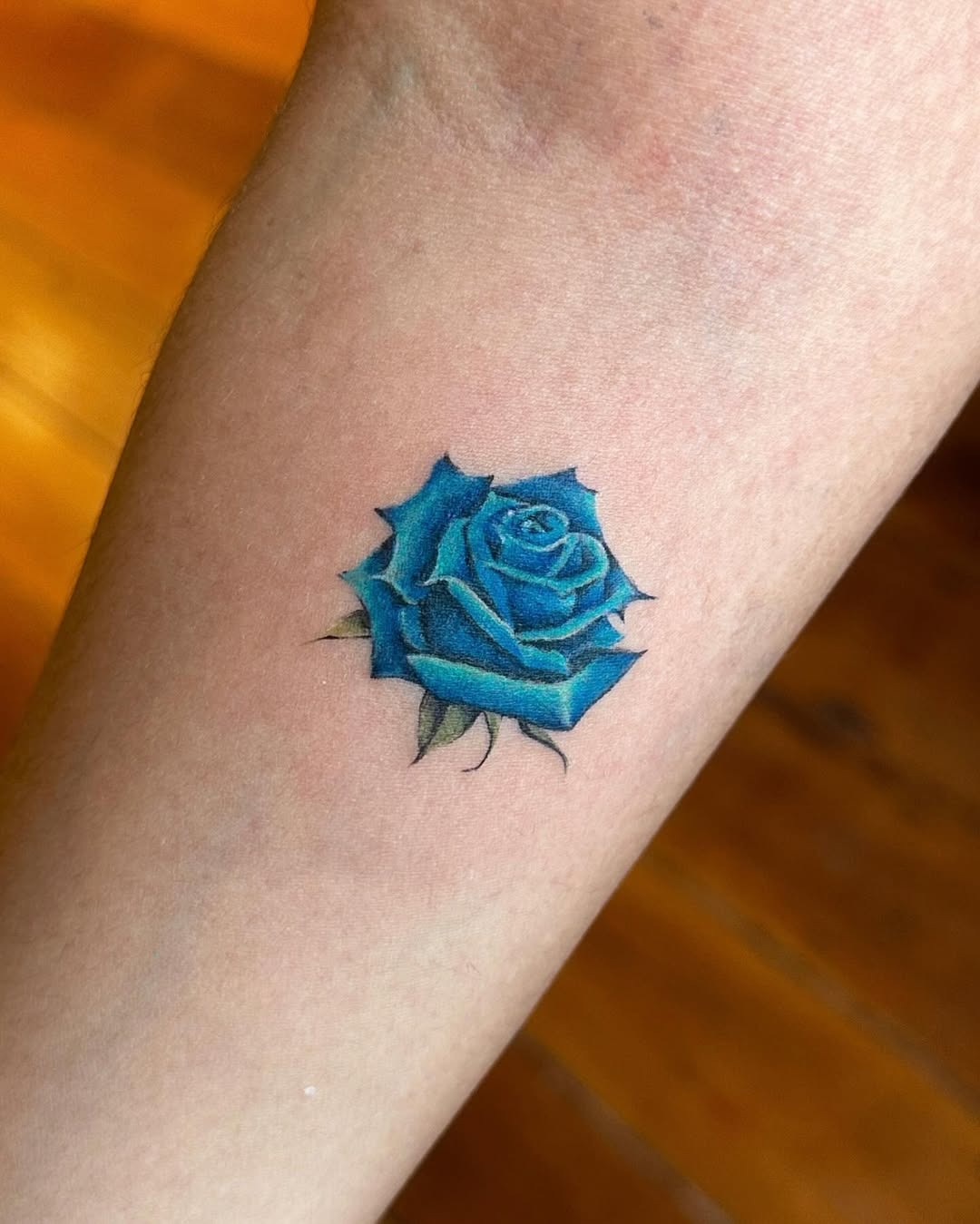 Vibrant blue rose tattoo showcasing intricate design Tattoo Design