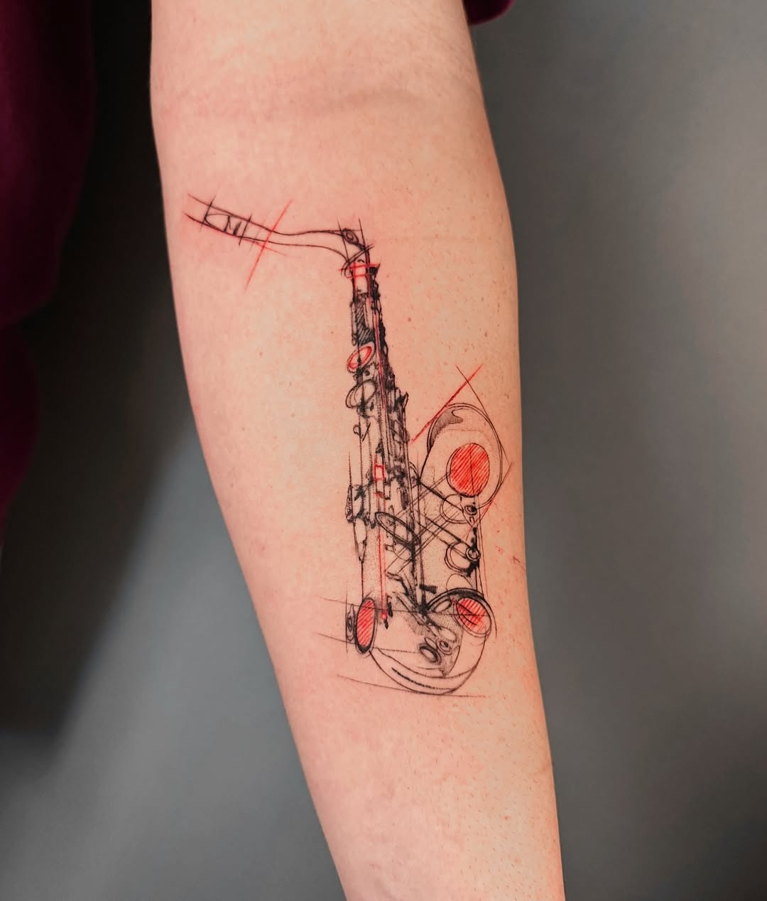 Artistic saxophone tattoo with bold red accents Tattoo Design