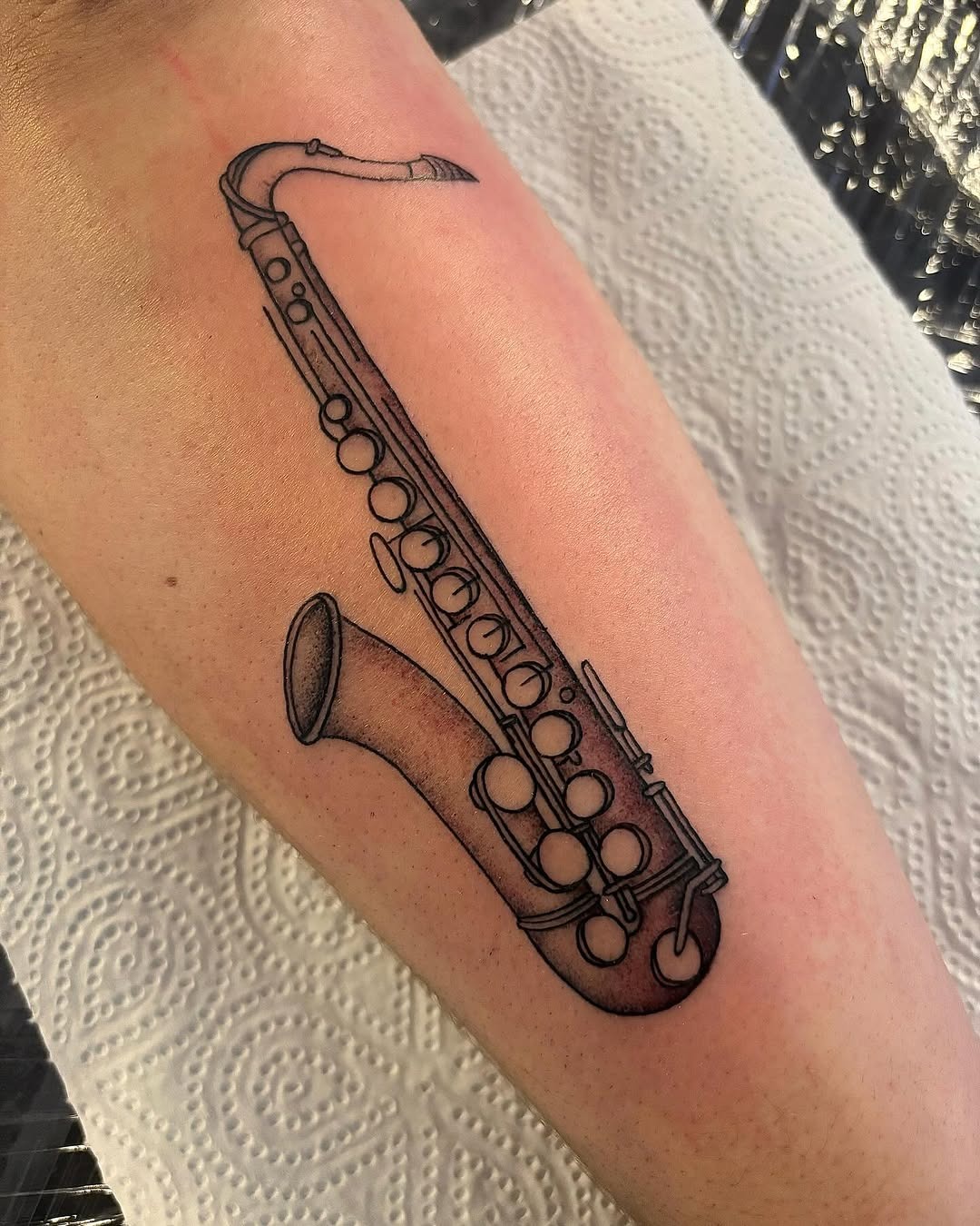 Elegant saxophone tattoo on forearm Tattoo Design