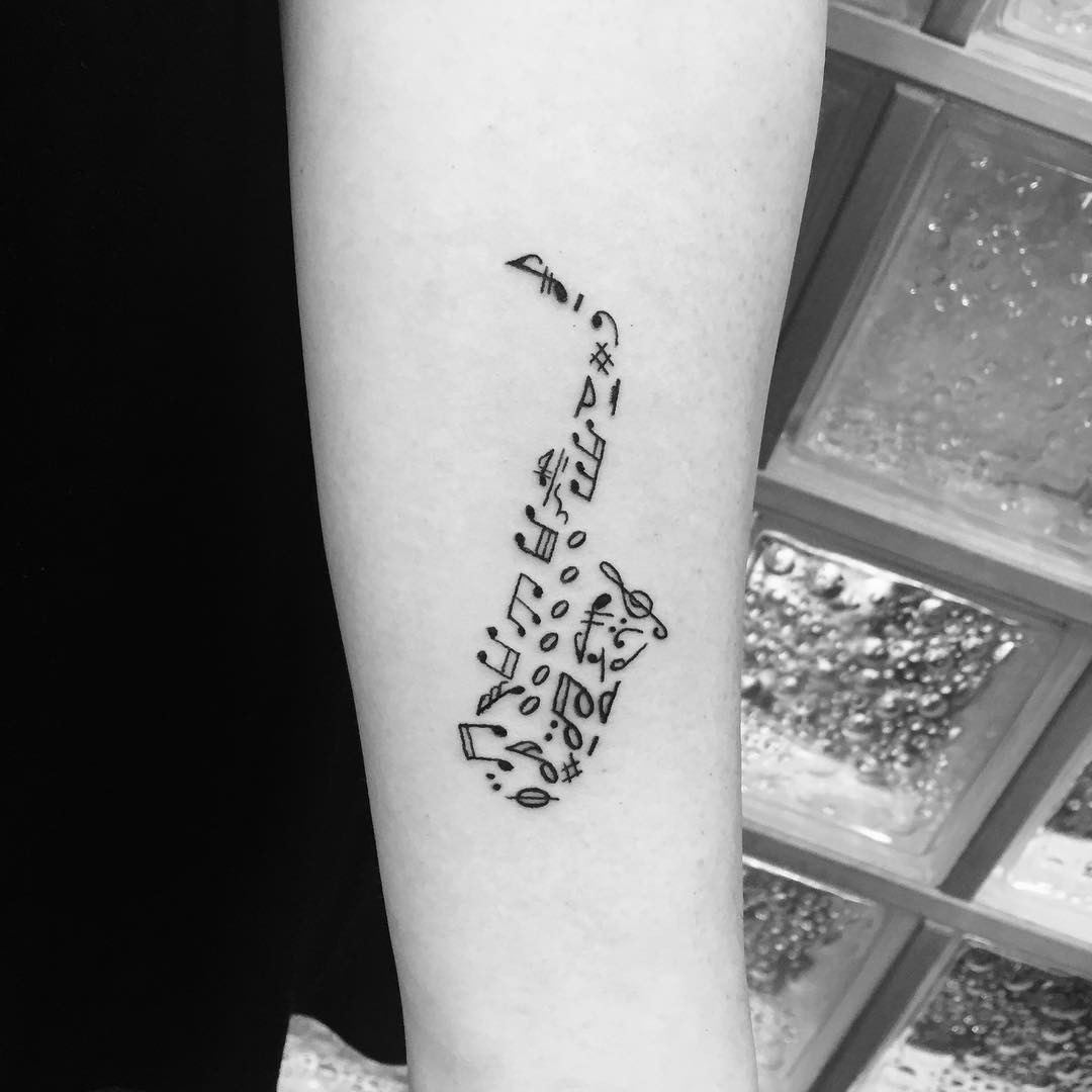 Elegant saxophone tattoo with musical notes inspiration Tattoo Design