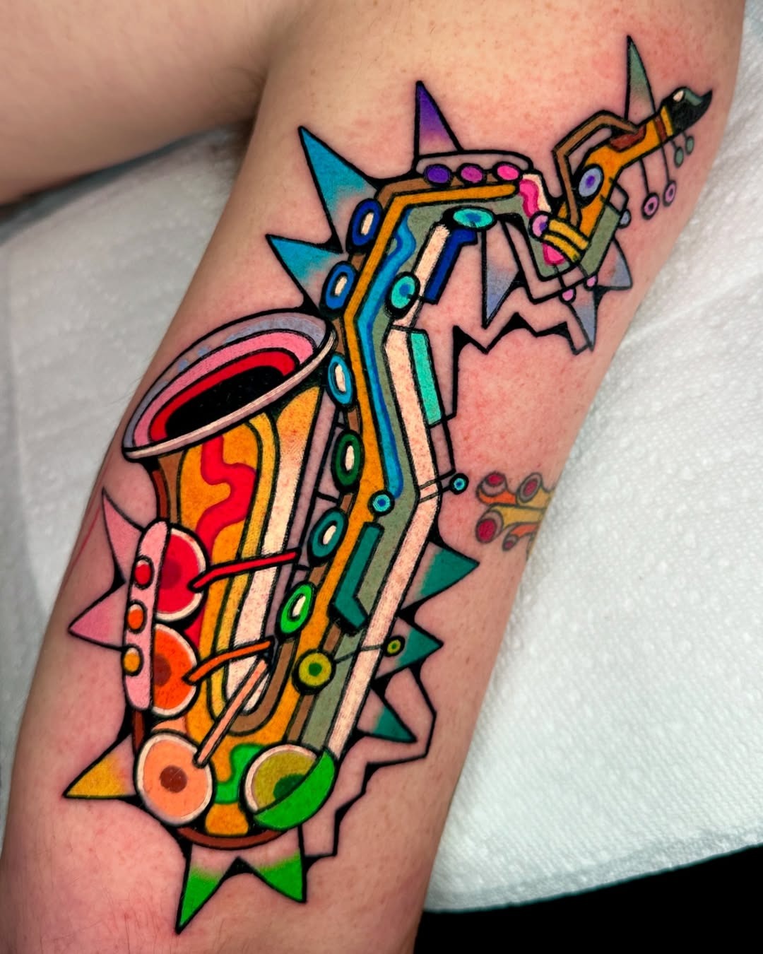 Vibrant saxophone tattoo bursting with color Tattoo Design