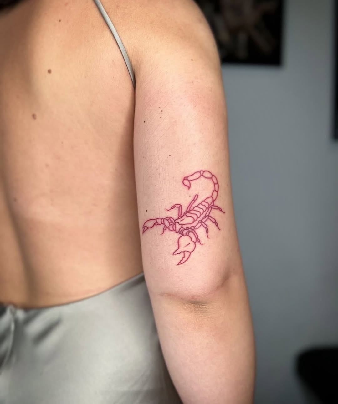 Elegant red scorpion tattoo on arm Tattoo Design