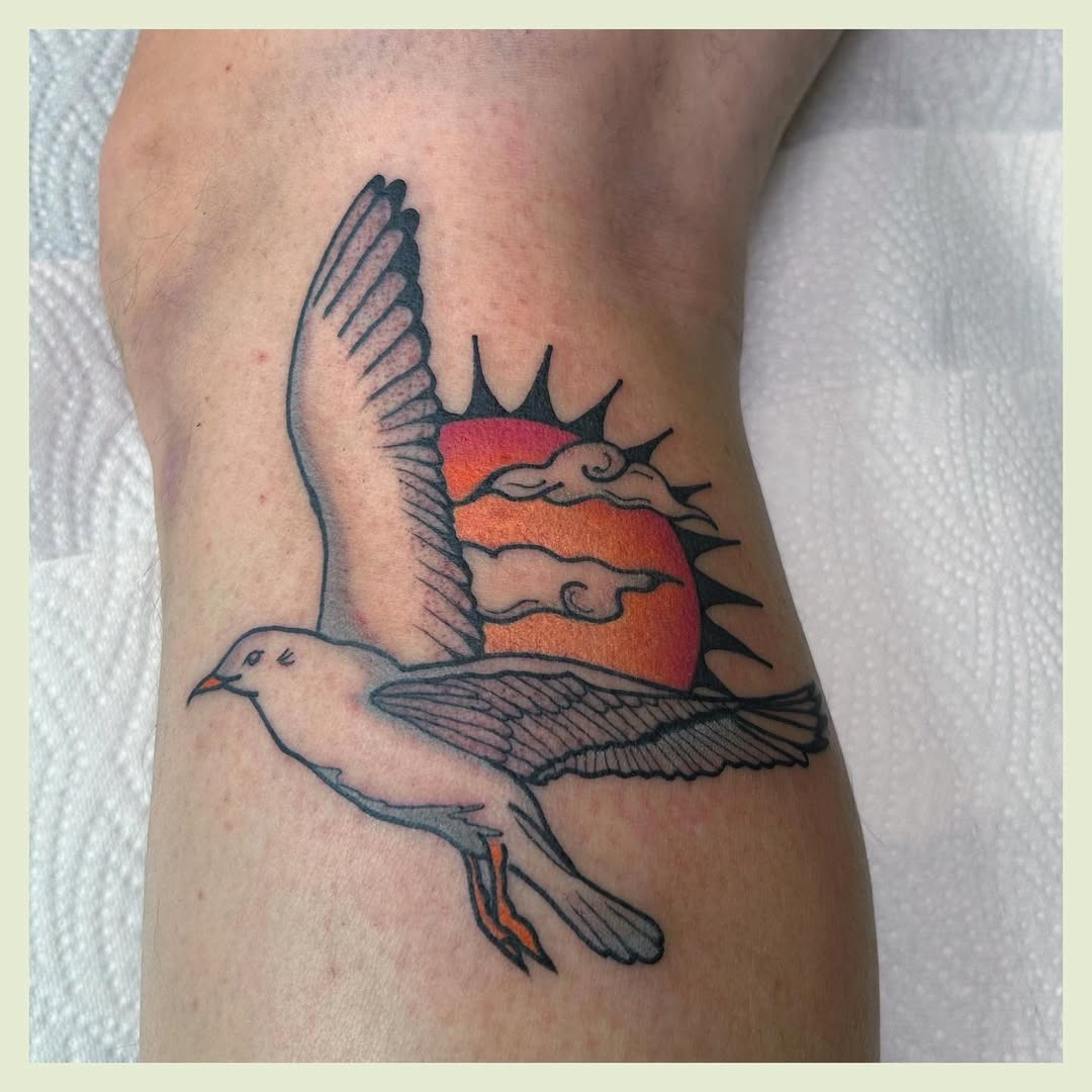 Elegant seagull soaring against a vibrant sunset Tattoo Design