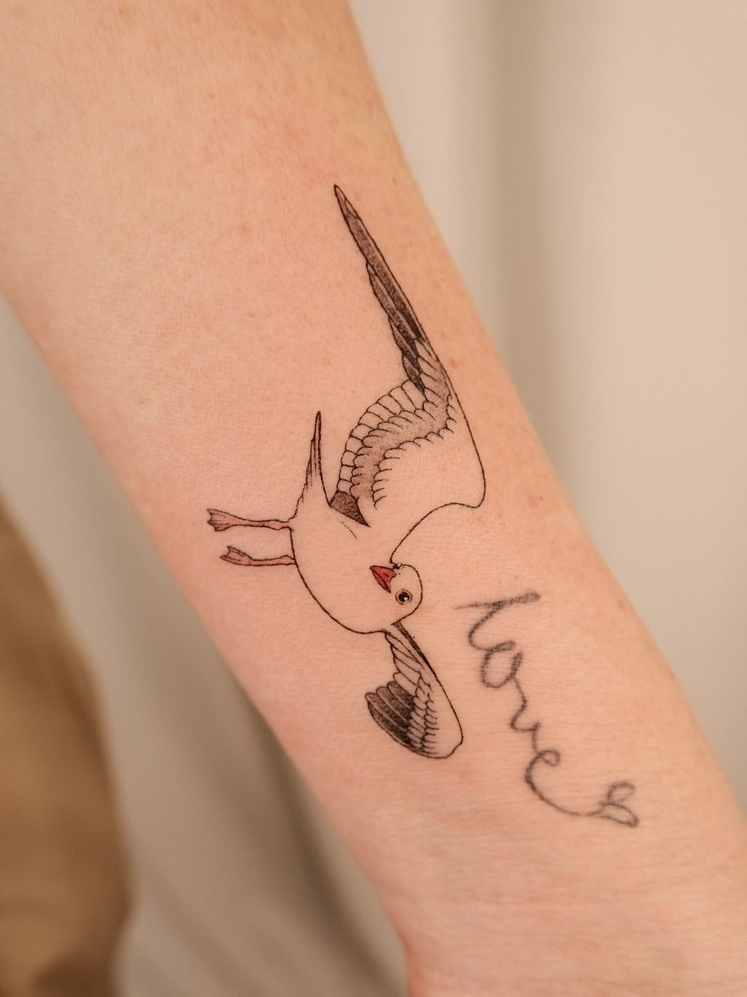 Elegant seagull tattoo with love script Tattoo Design