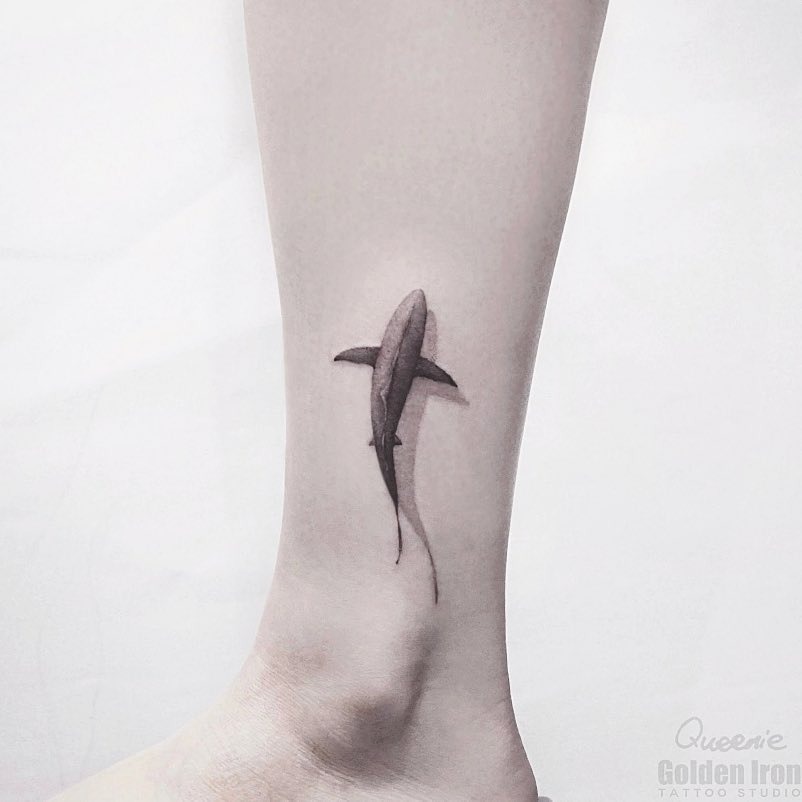 Minimalist shark tattoo on sleek leg Tattoo Design