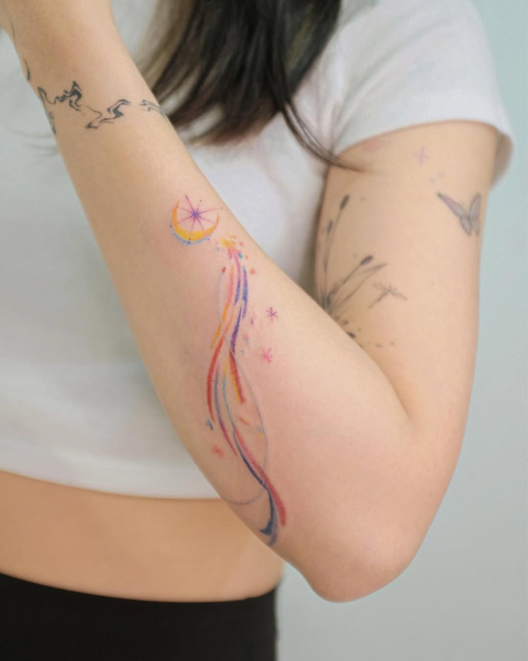 A whimsical shooting star tattoo with colorful trails Tattoo Design