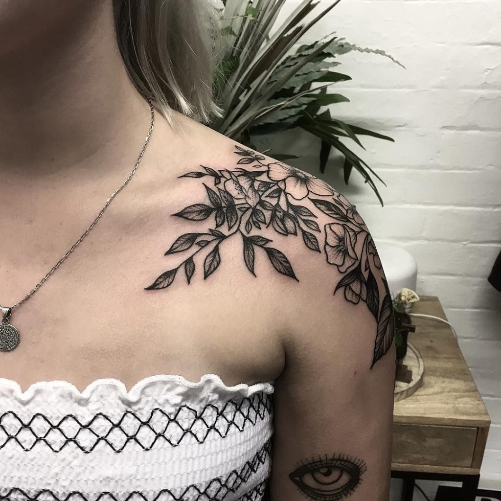 This botanic shoulder cap tattoo showcases intricate linework, creating a delicate and graceful feminine for women design.