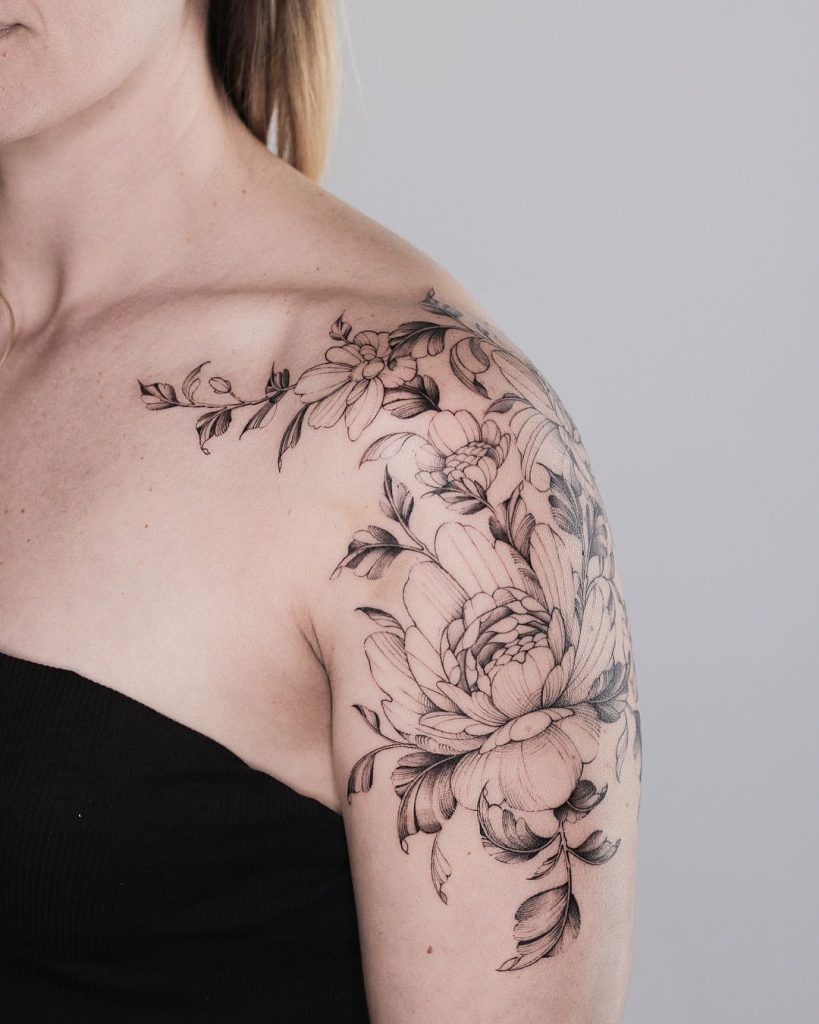 This women flower tattoo takes a softer, more artistic approach with its large blooming flowers and trailing leaves.