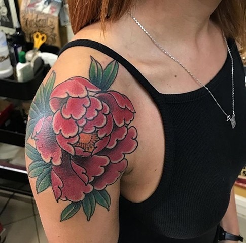 A bold and beautiful traditional tattoo for both men and women, this design features a striking red peony with deep green leaves.