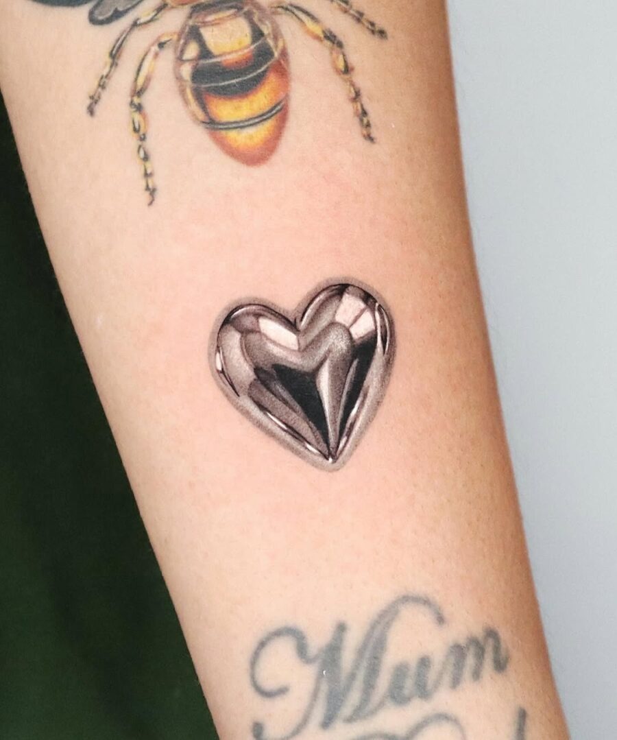 Chic silver heart tattoo design on skin Tattoo Design