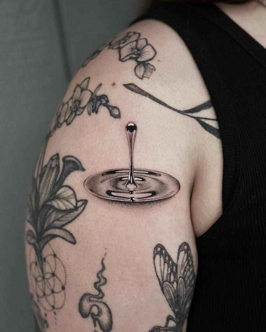 Striking silver droplet tattoo on the arm Tattoo Design