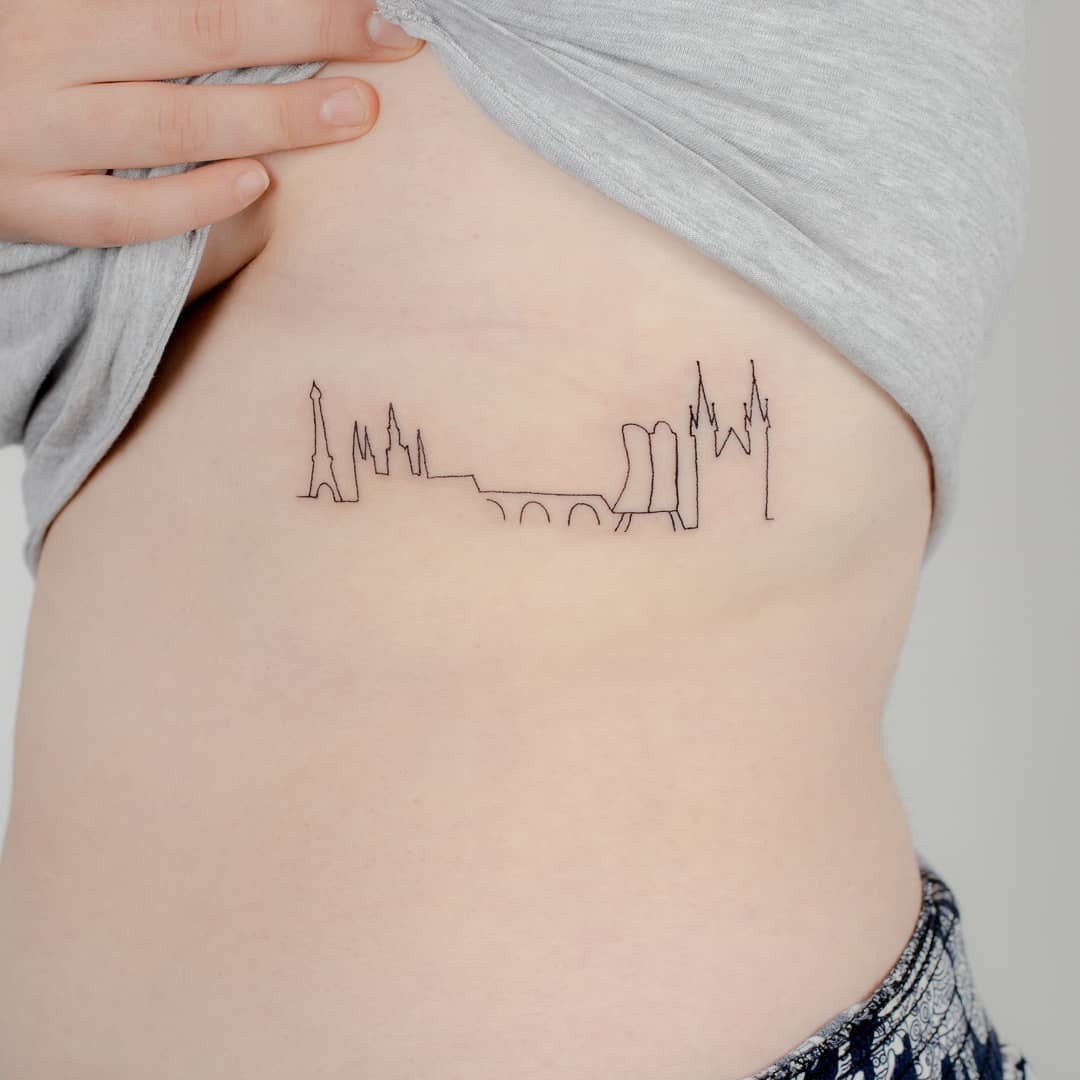 Stylish minimalist skyline tattoo on rib cage Tattoo Design