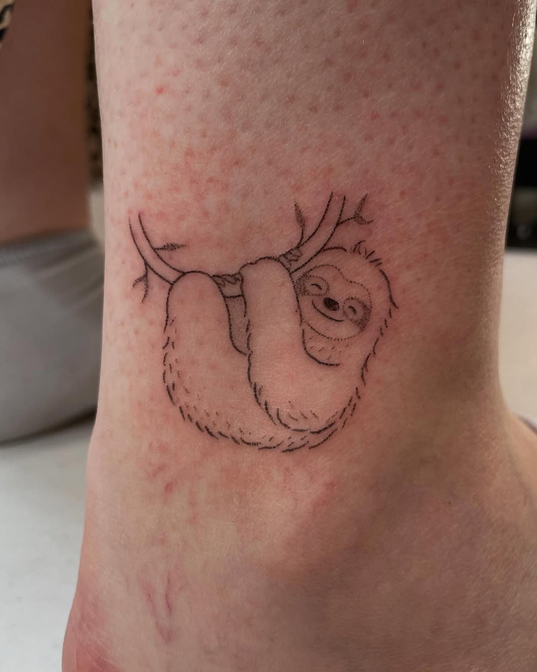 Charming Sloth Hanging from a Branch Tattoo Design