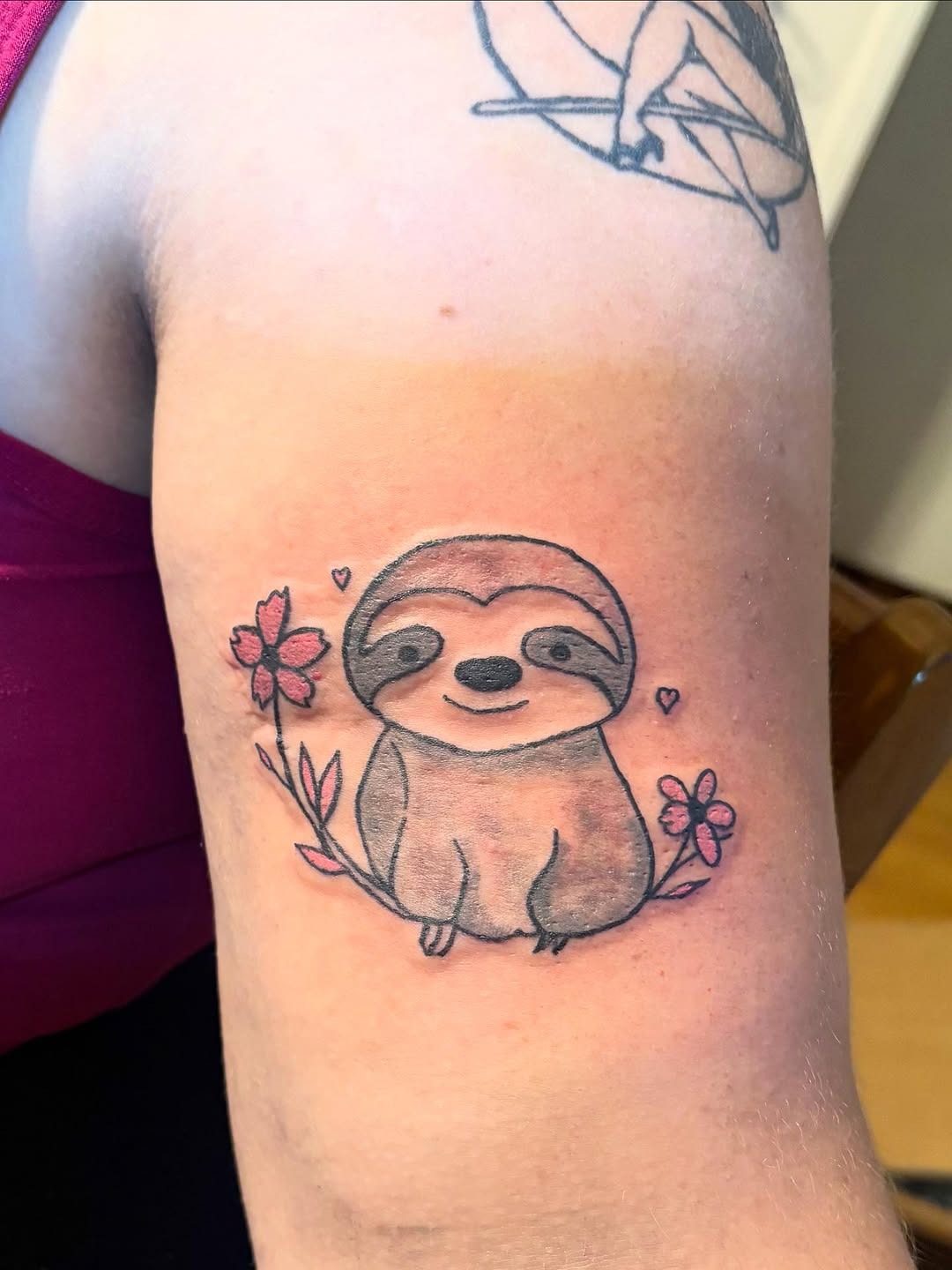 Charming sloth tattoo with floral accents Tattoo Design