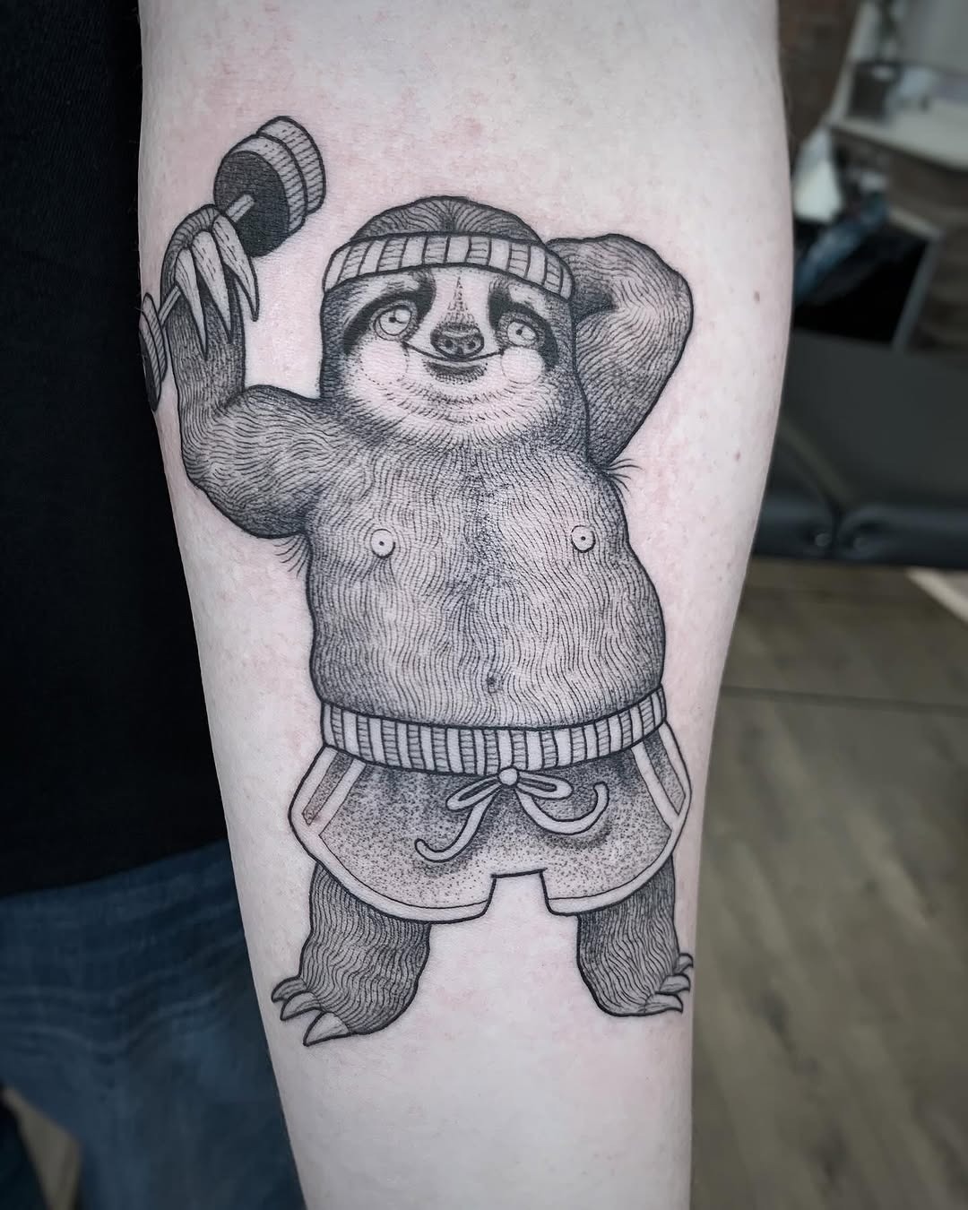 Playful sloth flexing with a dumbbell tattoo Tattoo Design