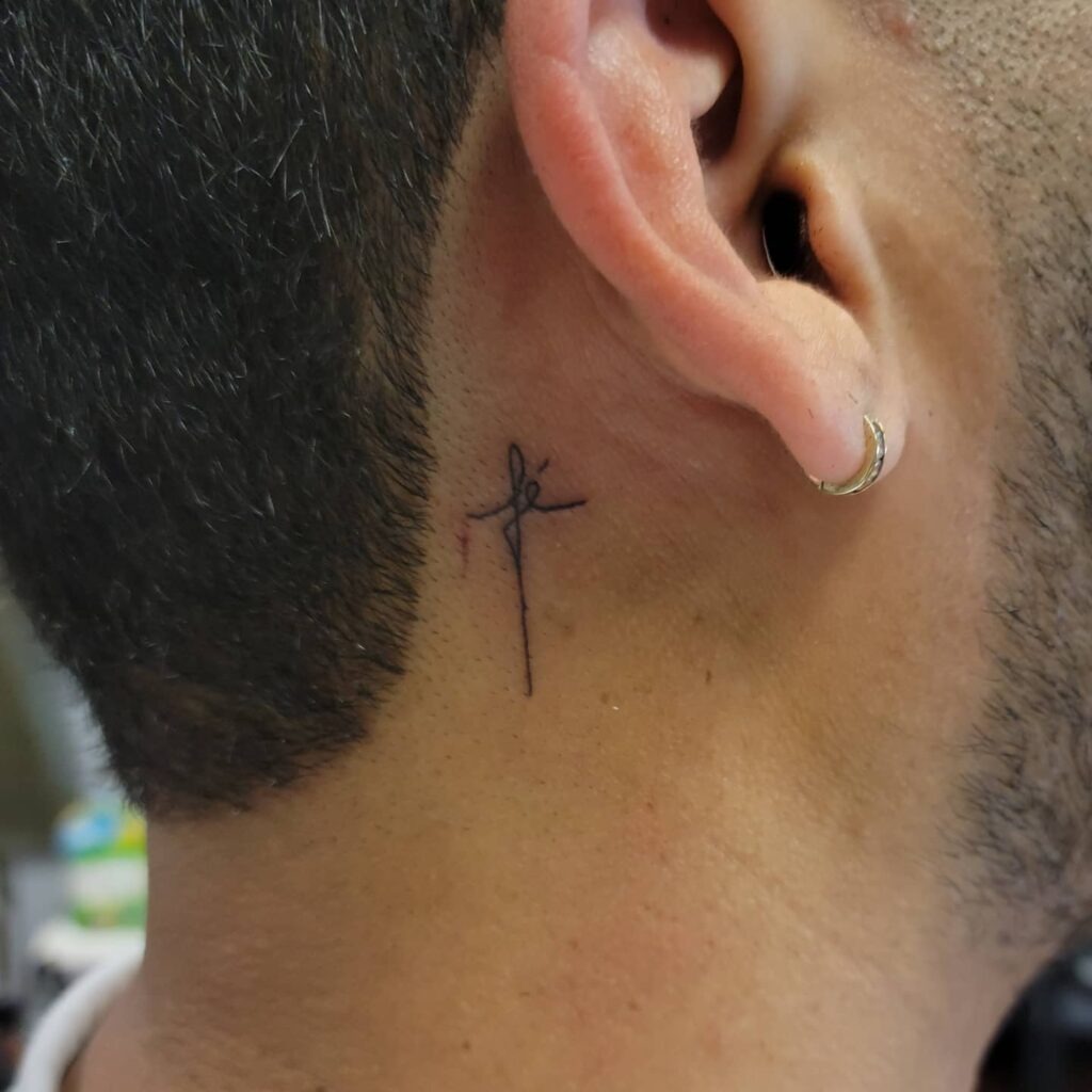Cross with "Fe" Script Behind the Ear Tattoo Design