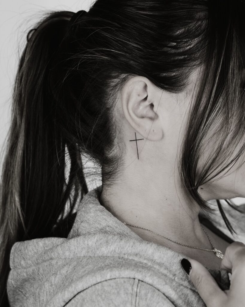 Elegant Thin Cross Behind the Ear Tattoo Design