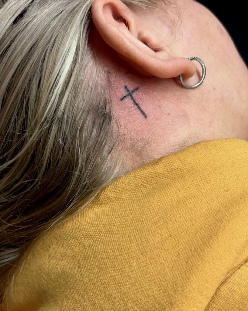 Minimal Black Cross Behind the Ear Tattoo Design