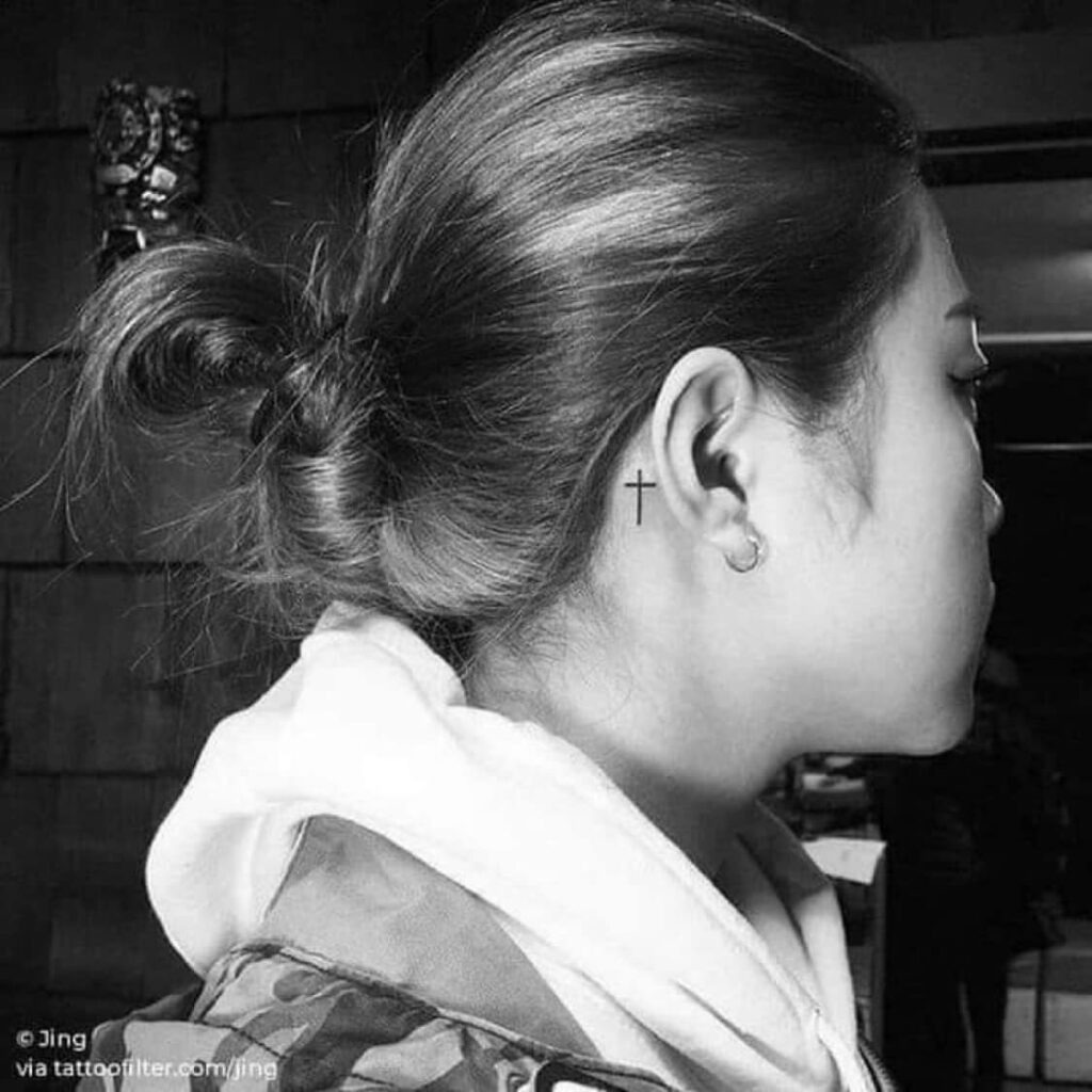 Tiny Black Cross Behind the Ear Tattoo Design