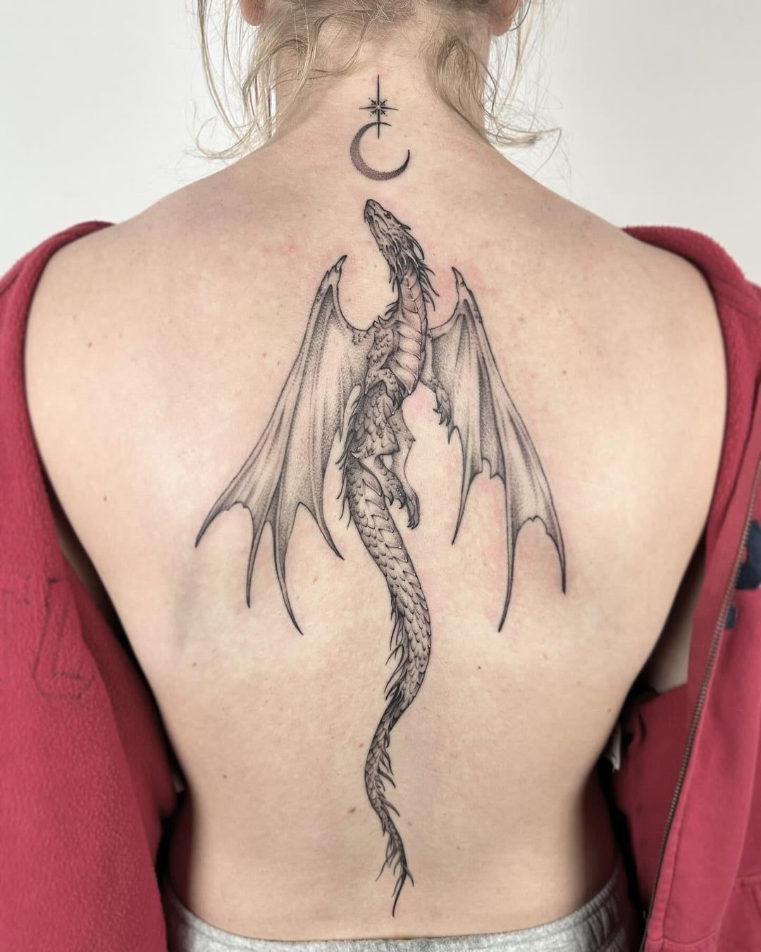 Minimal Winged Dragon Women Spine Black, a tattoo design rendered in fine-line for the shoulder.