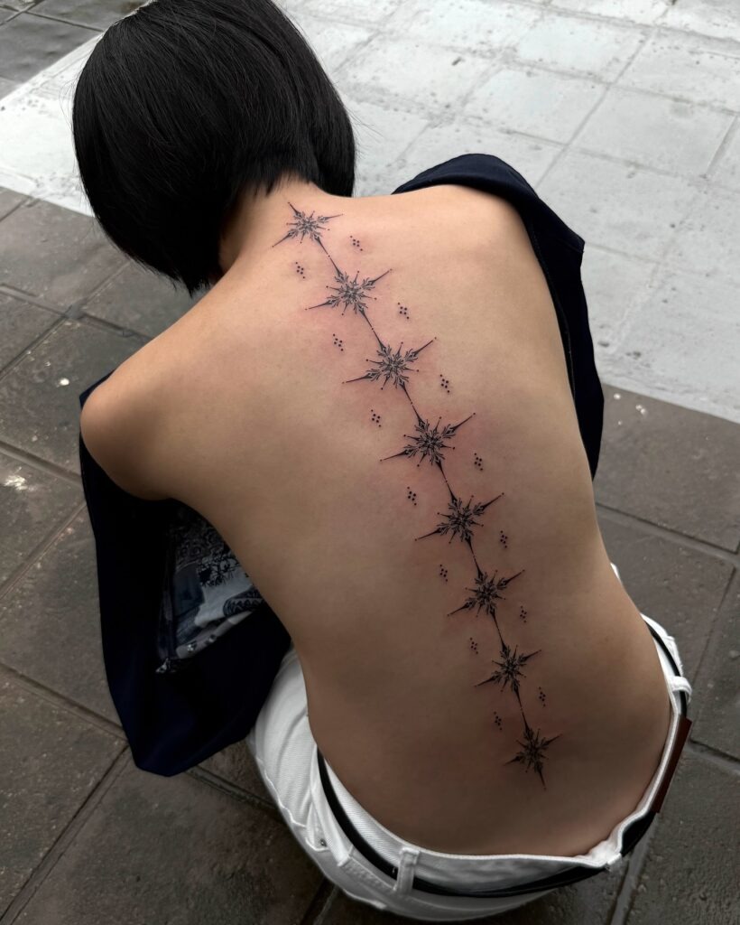 Sparkling Star Ornaments Flowing Along the Spine Tattoo Design
