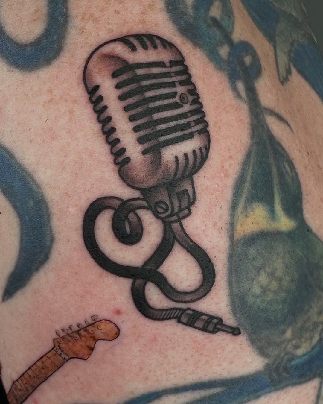 This vintage-style microphone tattoo captures the essence of music and creativity.