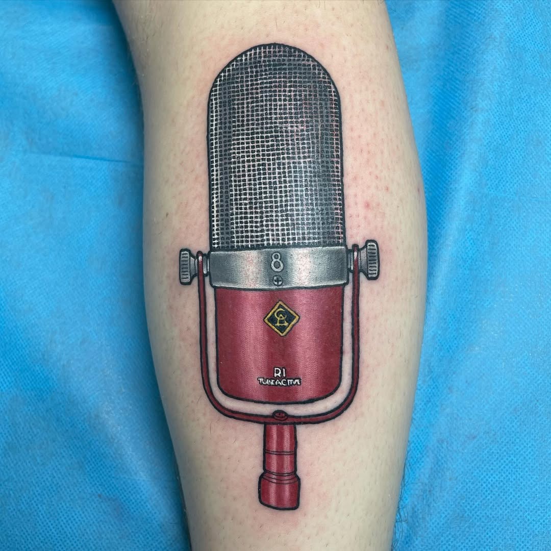 This colorful tattoo features a retro microphone with intricate detailing.