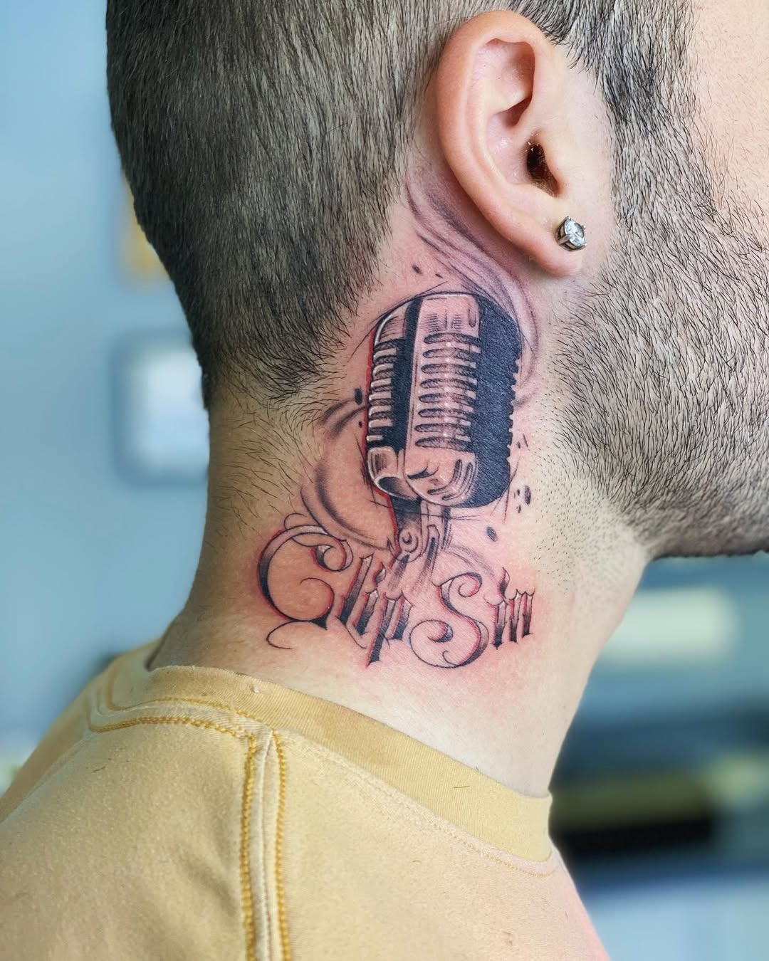 This eye-catching microphone tattoo is inked beautifully on the side of the neck, blending classic and contemporary art styles.