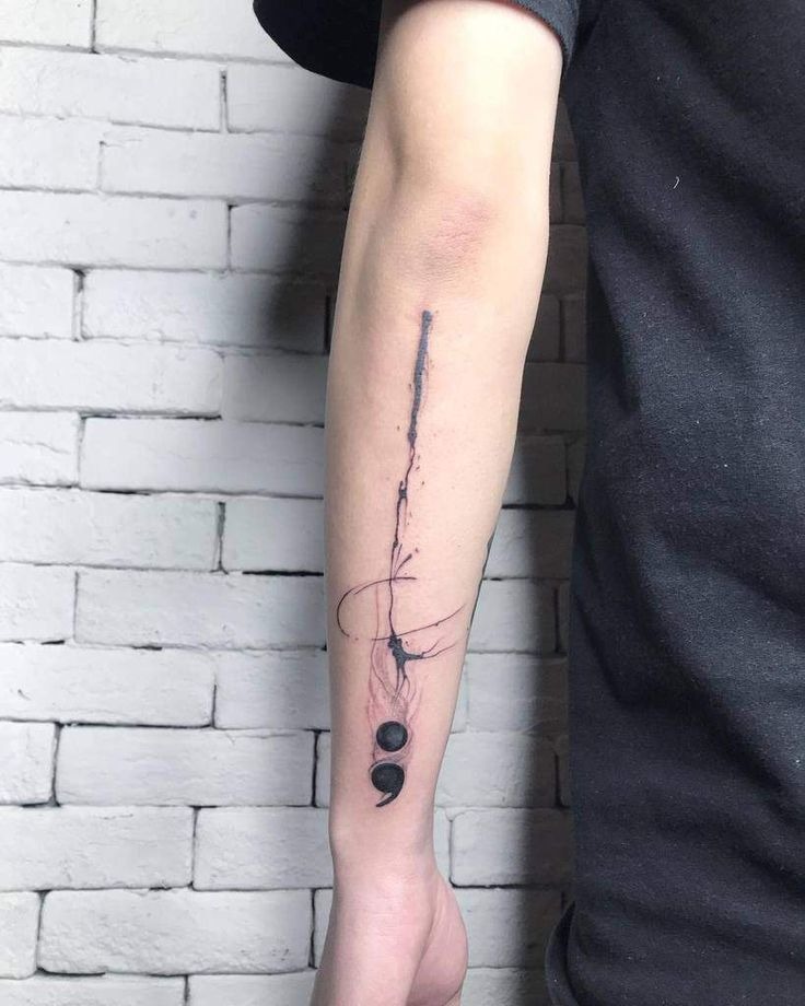 A modern take on the semicolon tattoo, this design incorporates abstract brushstroke elements with fine-line detailing.