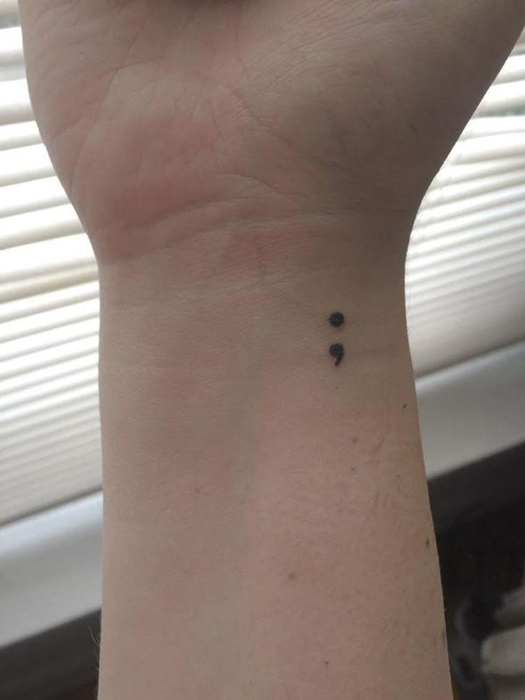 The simplest and most classic of all semicolon tattoos, this tiny design on the wrist is a timeless reminder of inner strength.