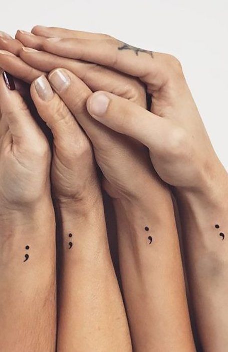 A series of identical tiny semicolon tattoos adorn the wrists of multiple people, representing solidarity and shared strength.