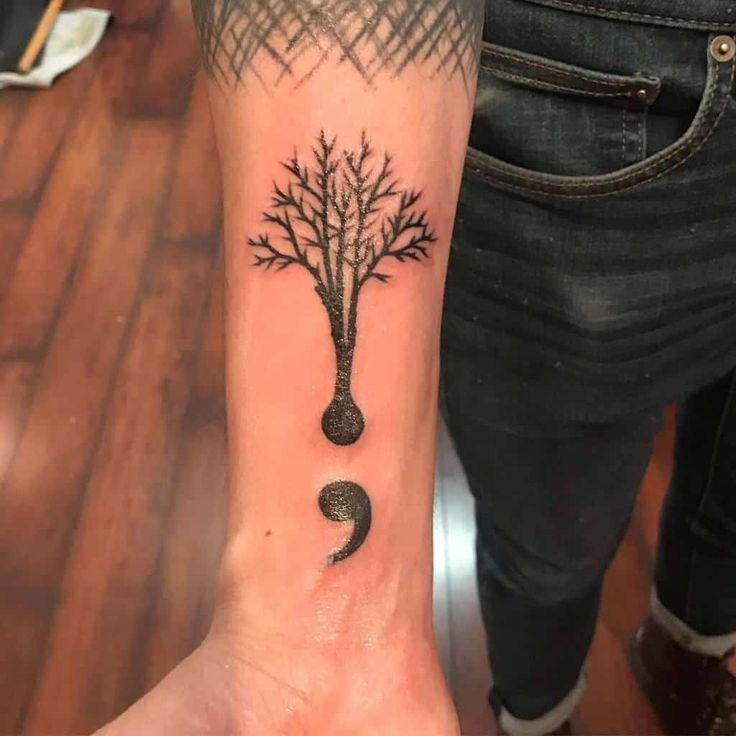 A striking combination of nature and symbolism, this tattoo transforms the semicolon into the base of a tree.