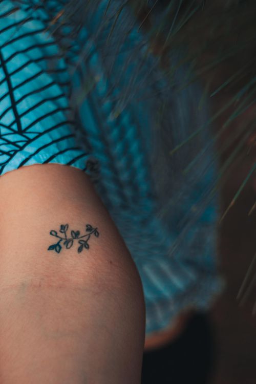 Small floral sprig tattoo on an arm