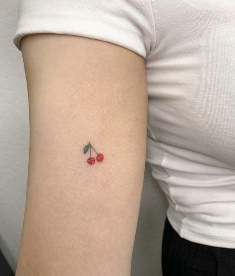 Tiny pair of cherry tattoos on an arm