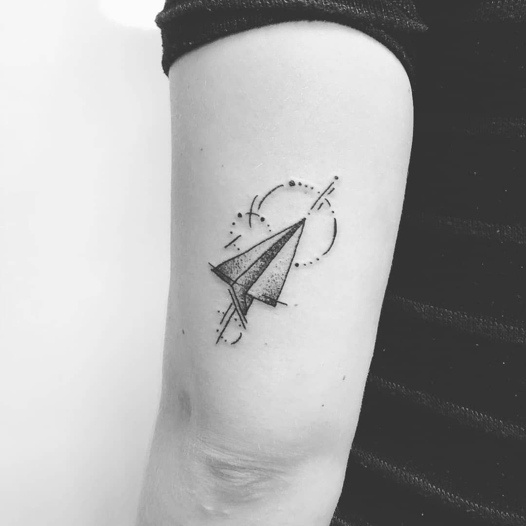 Paper plane tattoo on an arm
