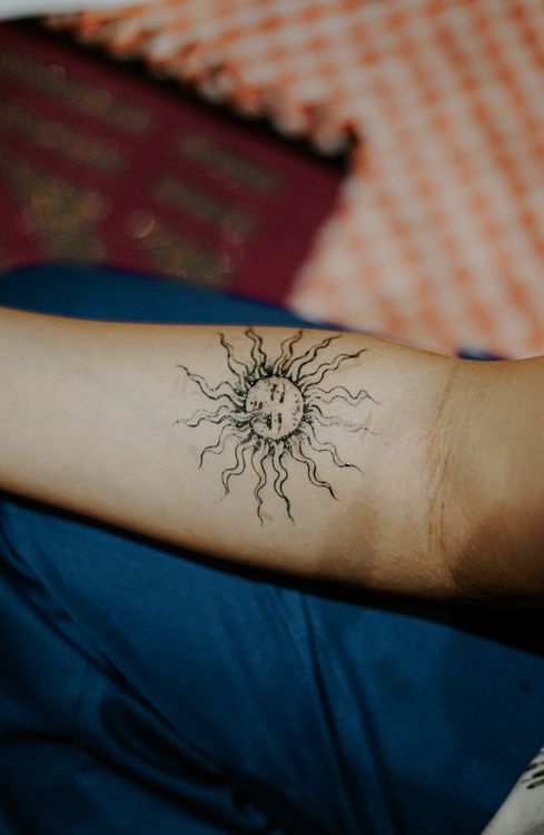 Small sun tattoo on an arm
