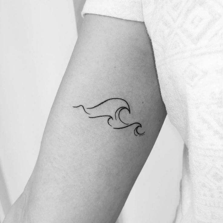 Minimalist wave line tattoo on an upper arm