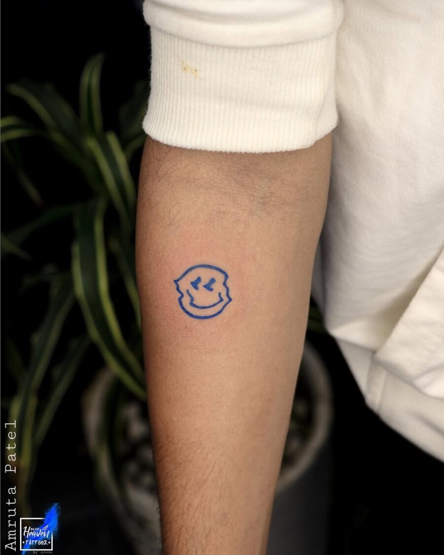 Charming blue smiley face tattoo on arm Tattoo Design