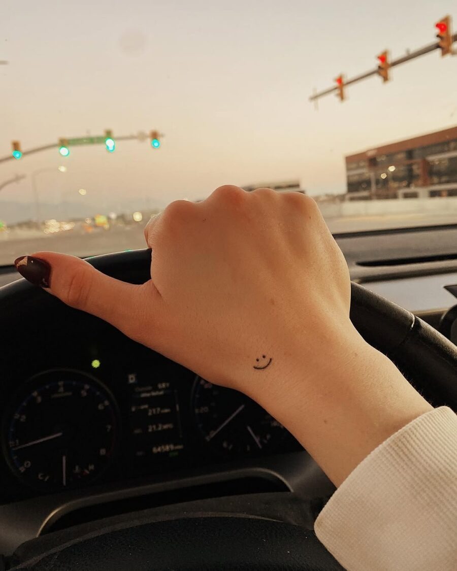 Charming smiley face tattoo on driving hand Tattoo Design