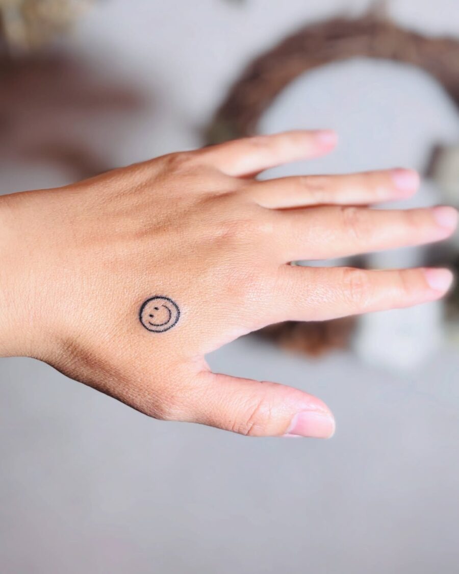 Charming smiley face tattoo on the hand Tattoo Design
