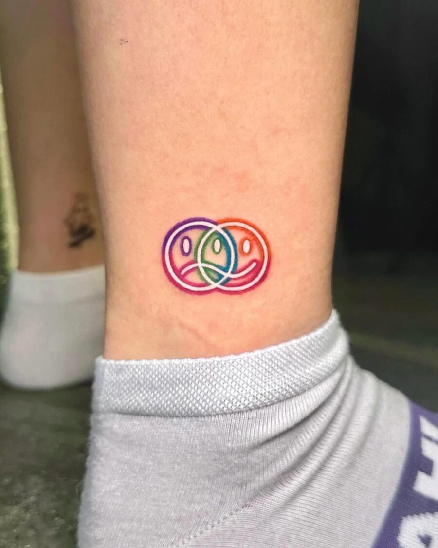 Colorful smiley faces in playful overlapping design Tattoo Design