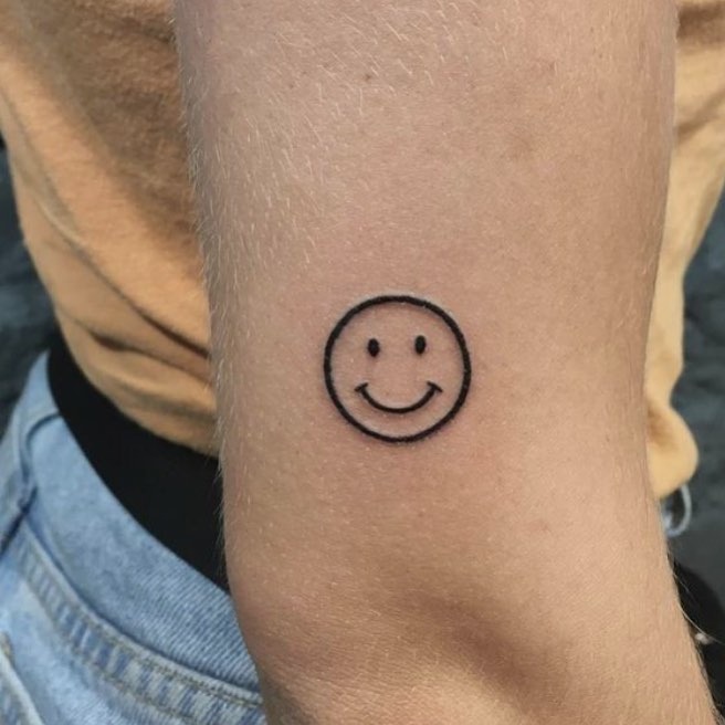 Minimalistic smiley face tattoo on forearm Tattoo Design