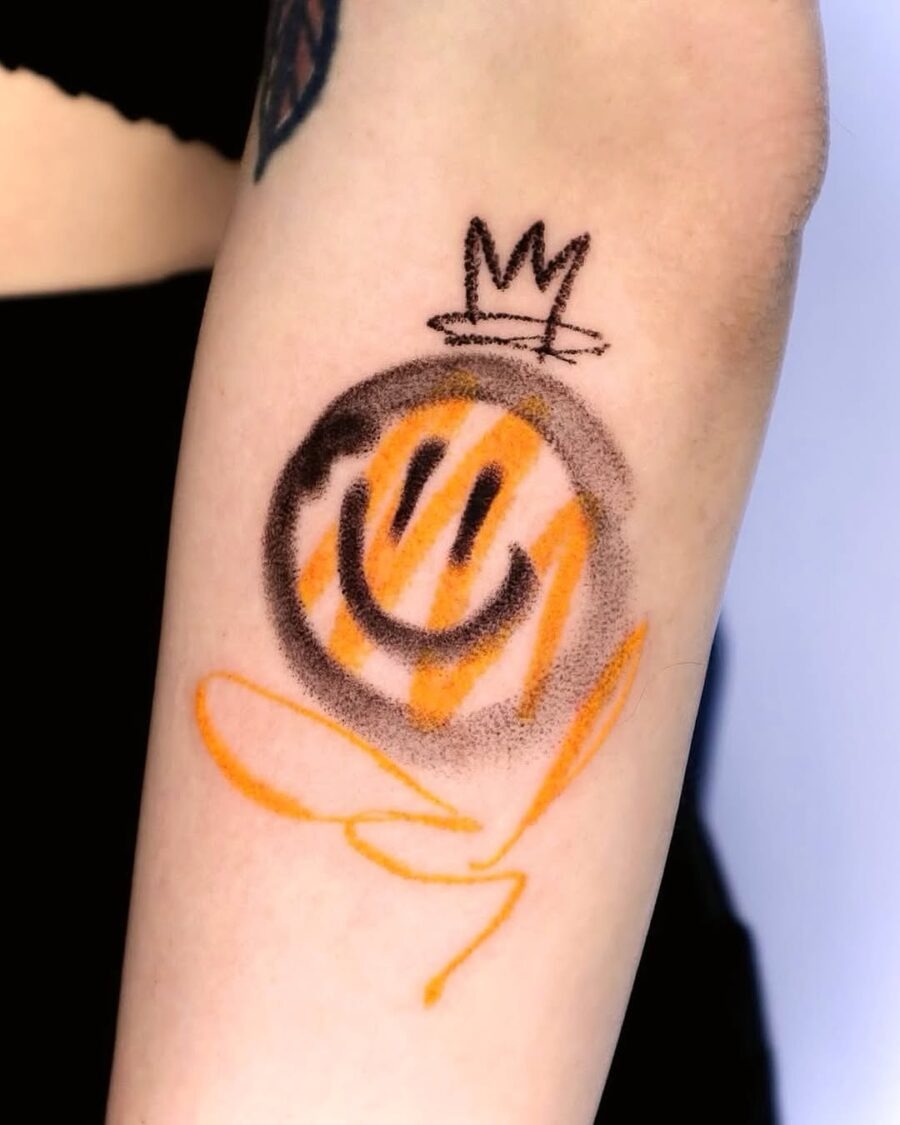 Playful smiley tattoo with a royal twist Tattoo Design