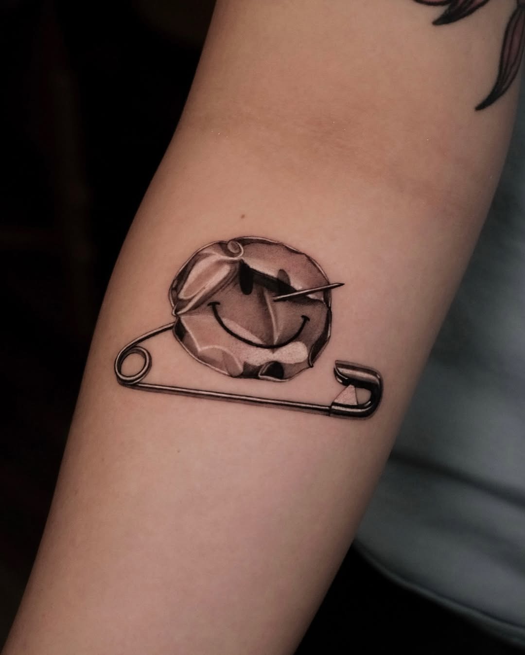 Quirky smiley face tattoo with safety pin Tattoo Design