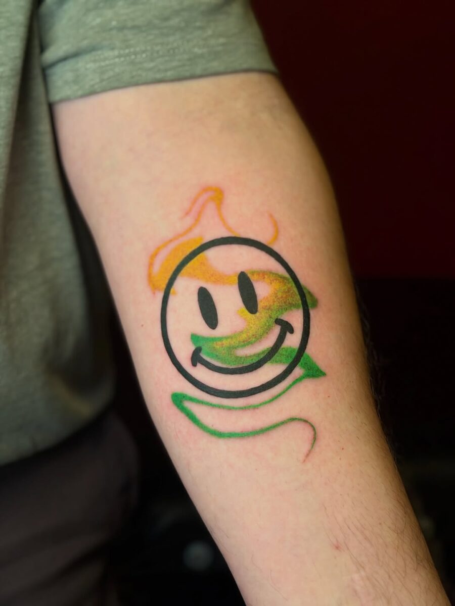Vibrant smiley face tattoo design on display Tattoo Design