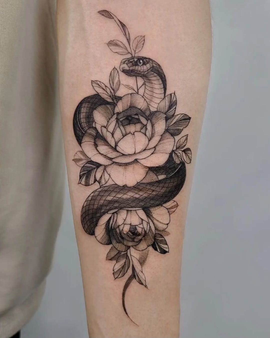 Elegant snake entwined with vibrant flowers Tattoo Design